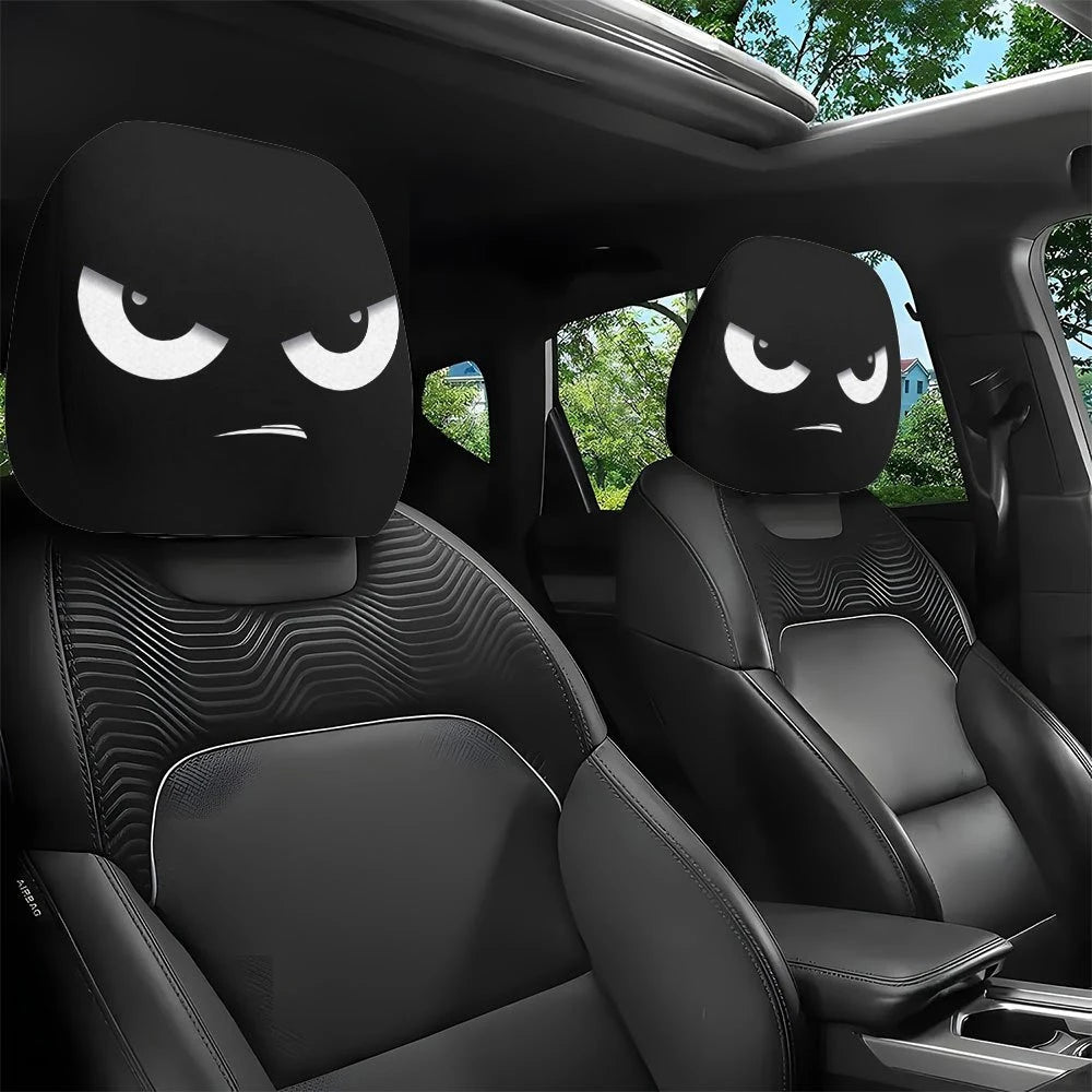 Two black car headrest covers with slanted eyes are shown inside a vehicle cabin.