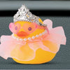 Three decorative rubber duck toys in yellow and pink with sparkling crowns and pearl necklaces.