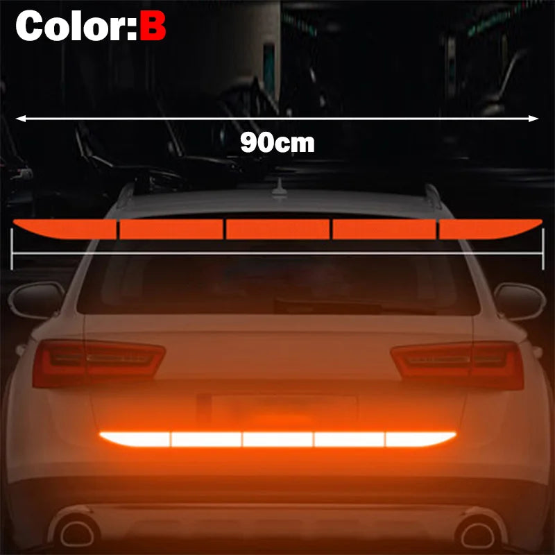A close-up view of a car's rear light assembly with an orange reflective safety sticker installed.