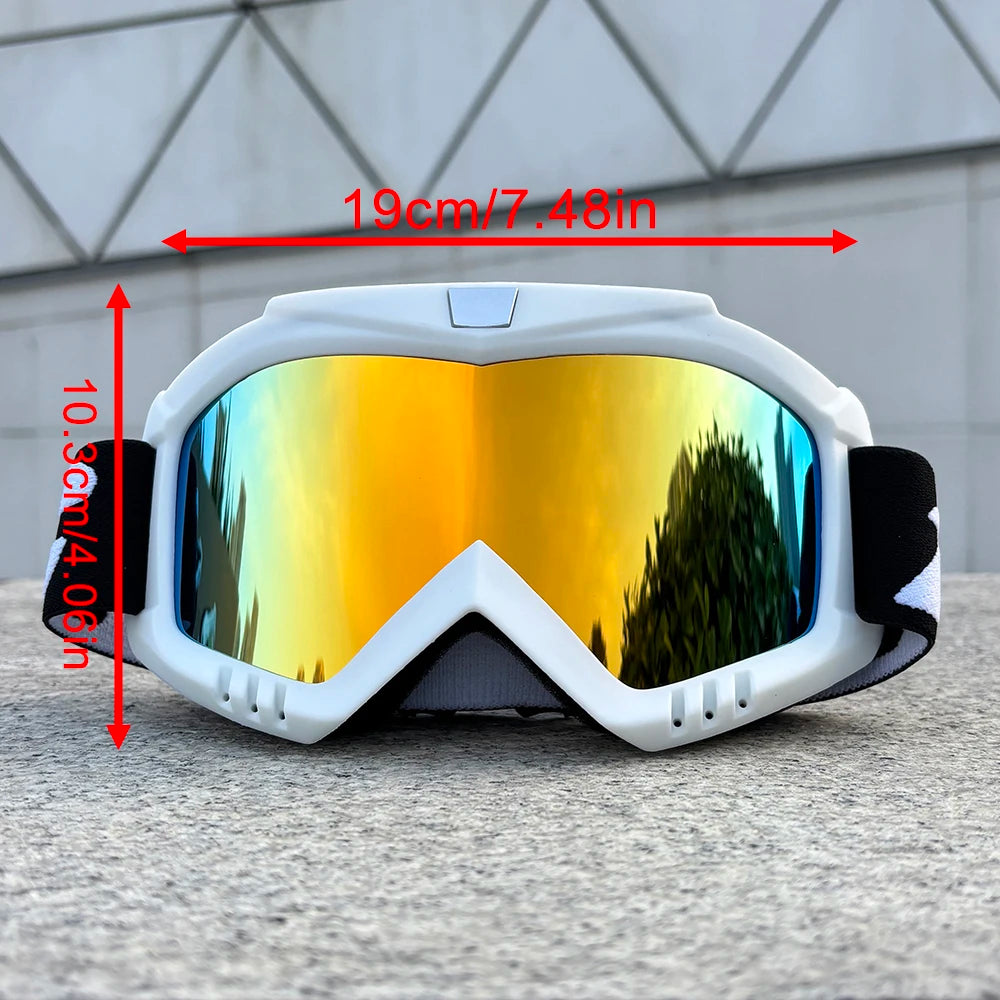 A pair of white windproof sports goggles with yellow-tinted lenses resting on a gray surface.