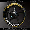 A close-up view of a motorcycle wheel featuring matte gold and white decals on the rim.