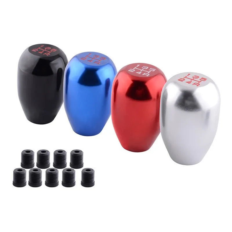 Set aus fünf farbigen Metall-Getriebsknöpfen in Schwarz, Blau, Rot und Silber sowie mehrere schwarze Gewindeeinsätze.