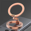 A rose gold magnetic phone ring stand with a dual-sided grip resting on a smartphone.