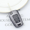 A close-up of a gray universal car key cover resting on a white circular background.