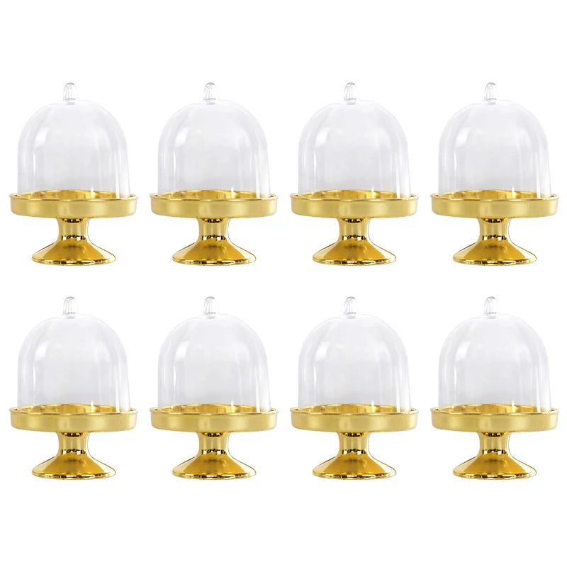 Set aus sechs goldfarbenen Mini-Cupcake-Ständer mit klaren Glaskuppeln.
