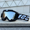 A pair of black windproof sports goggles with a white number 100 strap resting on a light gray surface.