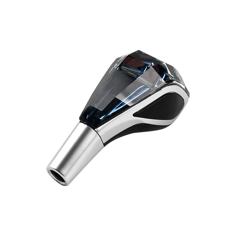 A close-up view of a silver and black LED glowing gear shift knob for a manual transmission.