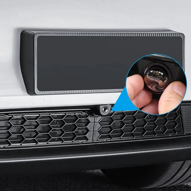 Close-up of a universal car camera protection film installed on a vehicle, showing the lens and mounting area.