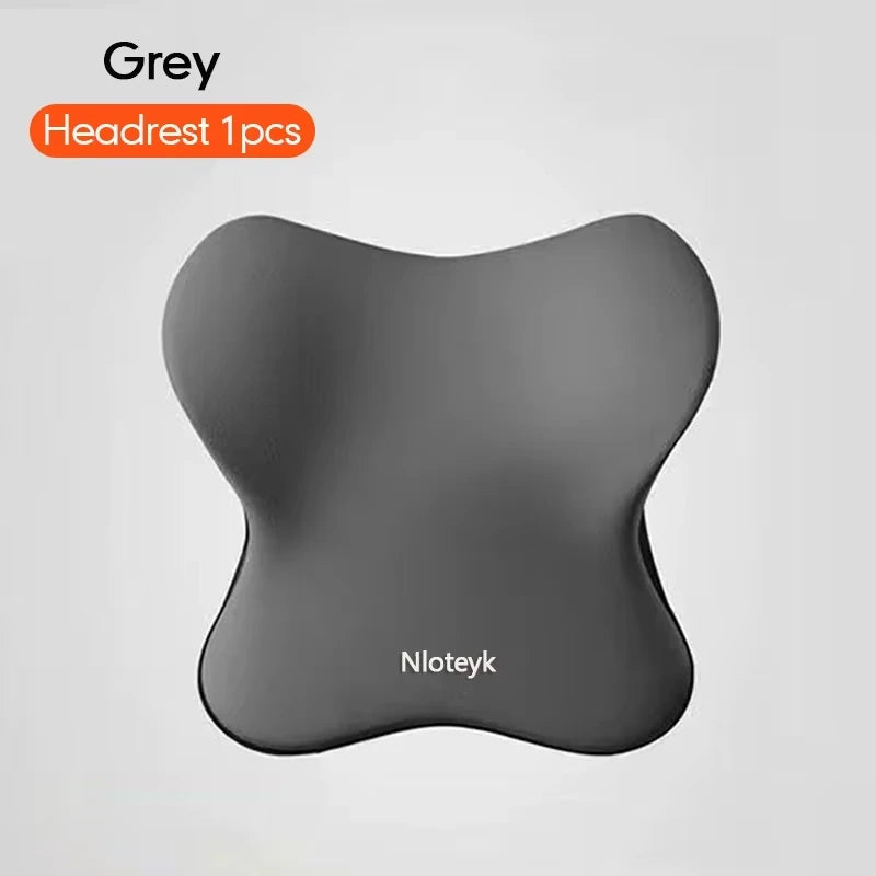 A grey ergonomic lumbar support pillow is shown against a light background.