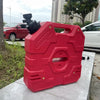 A red universal fuel can to water tap adapter with a black nozzle is displayed on a concrete surface.