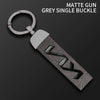 A matte grey single buckle gun key featuring a silver loop and a textured leather case.