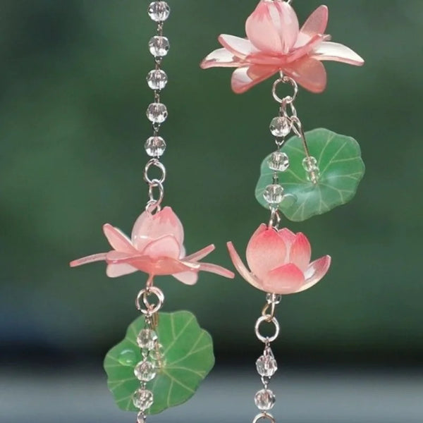 A delicate pink lotus flower pendant ornament featuring translucent pink petals and green leaves.