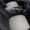 Interior view of a car seat showing a beige breathable cushion and dark upholstery.