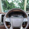Interior view of a steering wheel and dashboard trim panel for a Chevrolet Silverado or GMC Sierra truck.