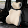 A beige ergonomic memory foam car neck and lumbar support pillow placed in a black car seat.