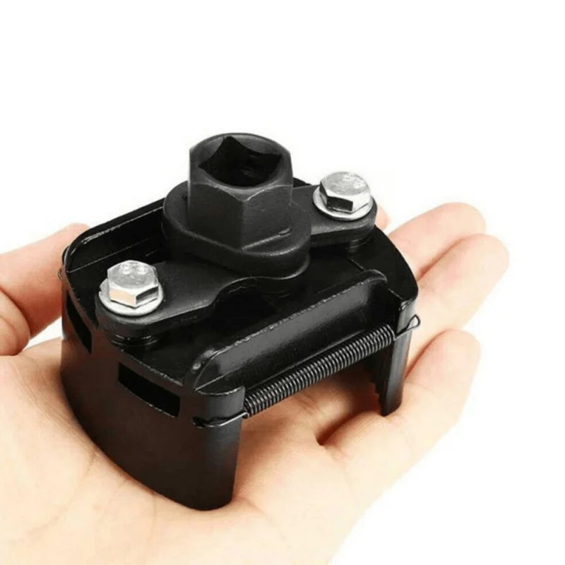 A black adjustable oil filter wrench with serrated jaws is held in a hand.