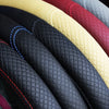 A close-up view of several anti-slip leather steering wheel covers in various colors like black, red, and beige.