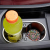 A set of silicone coasters featuring a green disc and an orange disc are placed in a dark compartment.
