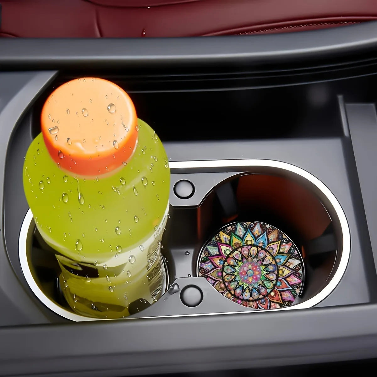 A set of silicone coasters featuring a green disc and an orange disc are placed in a dark compartment.