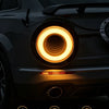 A close-up of a 4 inch round LED truck tail light with a bright yellow halo effect on a dark vehicle.