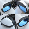 Carbon fiber rain shield covering a car's rearview mirror, showing blue light through the lens.