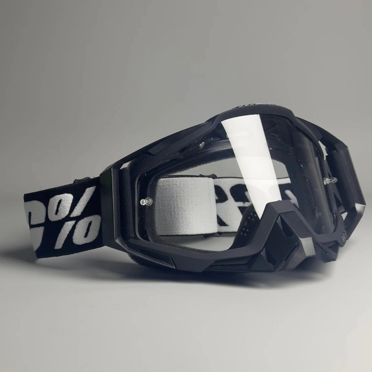 Black off-road motorcycle riding goggles with a clear lens and black strap