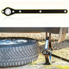 A black heavy-duty ratchet wrench with a star-shaped opening is shown next to a tire and jack.