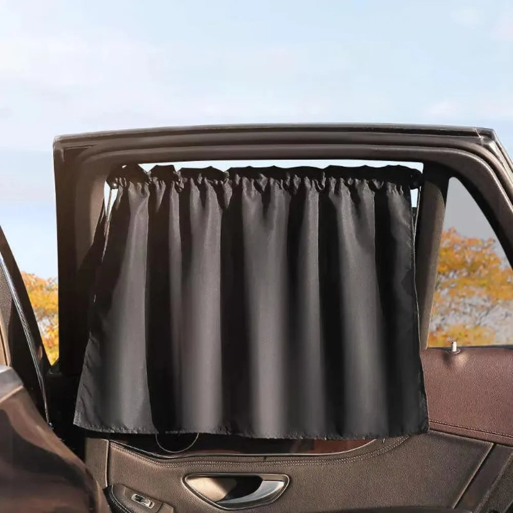A black suction cup window sunshade is installed in a car window frame.