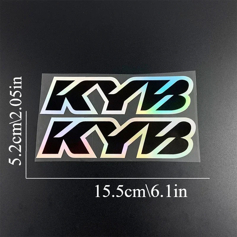 A pair of black and iridescent racing suspension decals for motorcycles, measuring 5.2cm by 15.5cm.