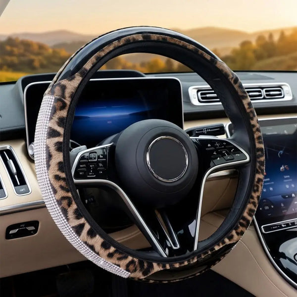 A close-up view of a steering wheel with a leopard print cover and rhinestone accents inside a car interior.