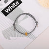 A black and white striped heart-shaped fitness tracker bracelet is displayed on a white background.