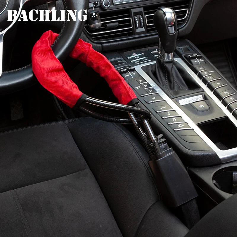A red seatbelt is visible across a black steering wheel and interior of a car, featuring a modern gear shift and controls.