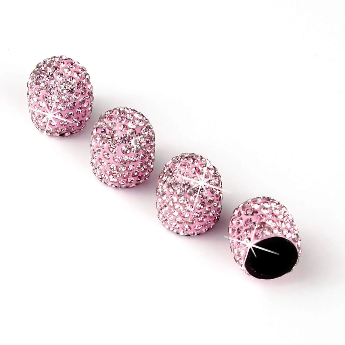 Vier rosa Glitzer-Diamant-Radkappen in einer Reihe auf weißem Hintergrund.
