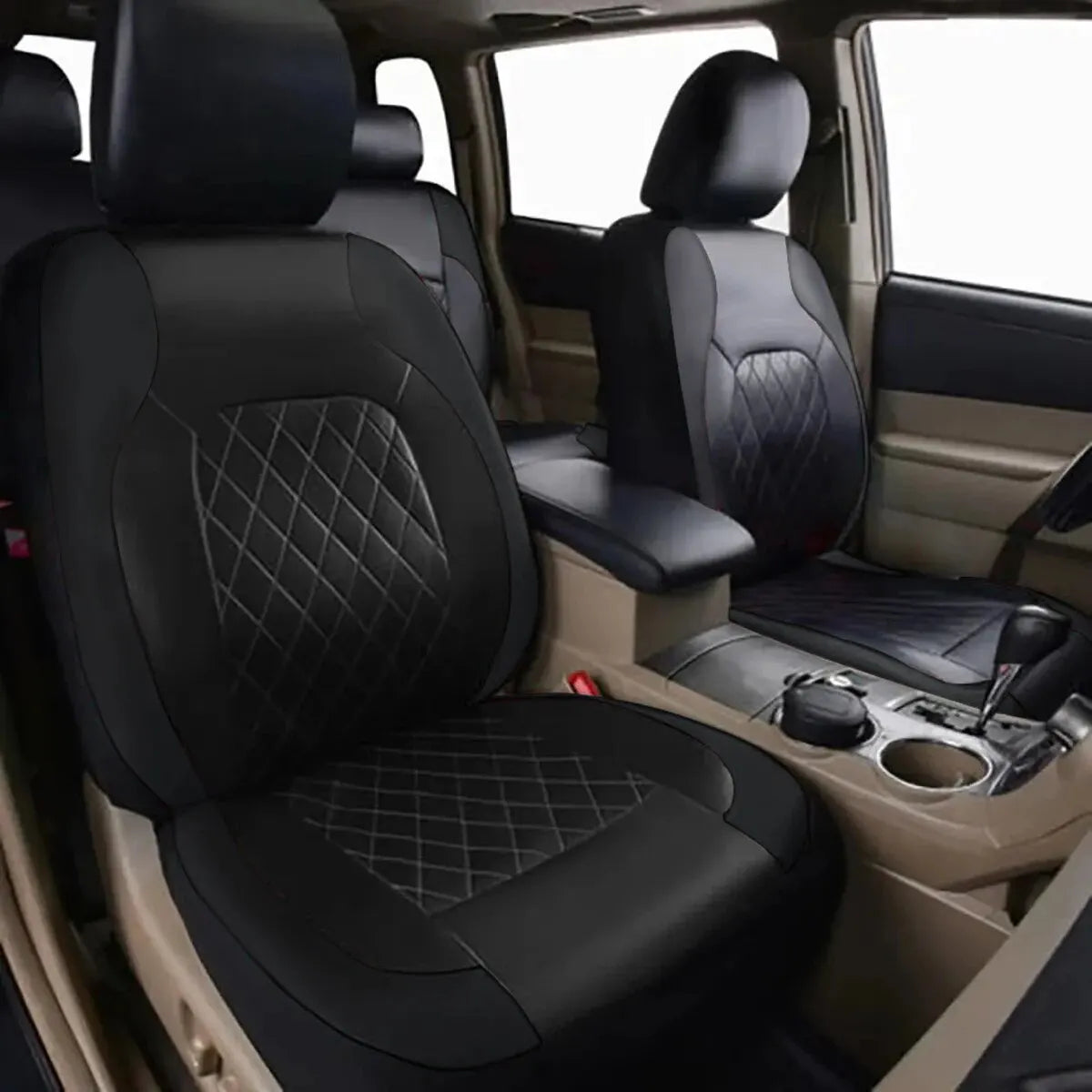 Interior view of a car with black leather seat covers and tan upholstery.
