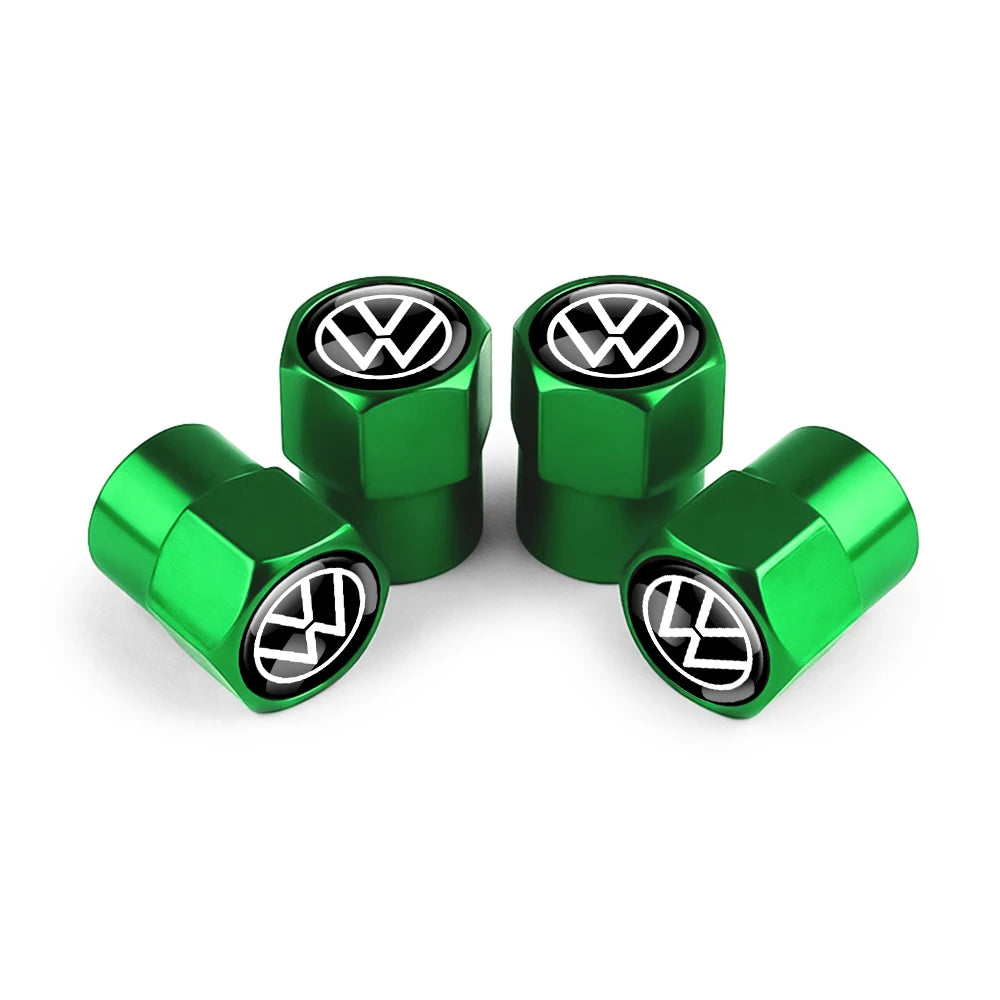 Three green metal tire valve caps with Volkswagen logos displayed on a white background.
