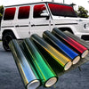 Rolls of two-tone gradient car window tint film displayed on a rack next to a white SUV.