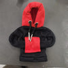 A red and black hoodie cover with a hood and a red patch on the front.