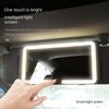 A hand touches a smart light screen vanity mirror mounted in a car interior.