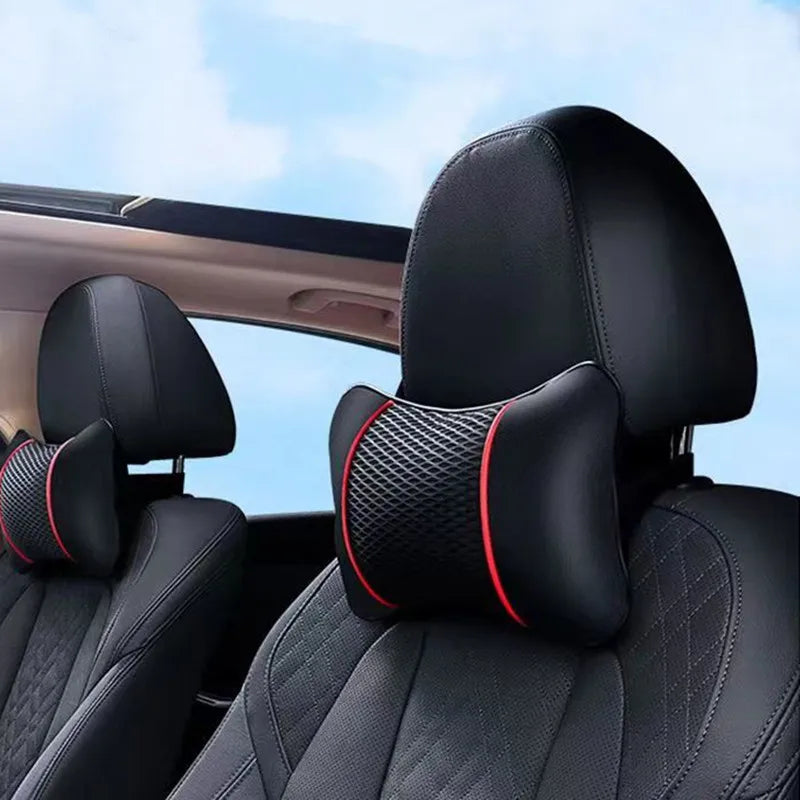 Black leather car headrest pillows visible inside a vehicle cabin.