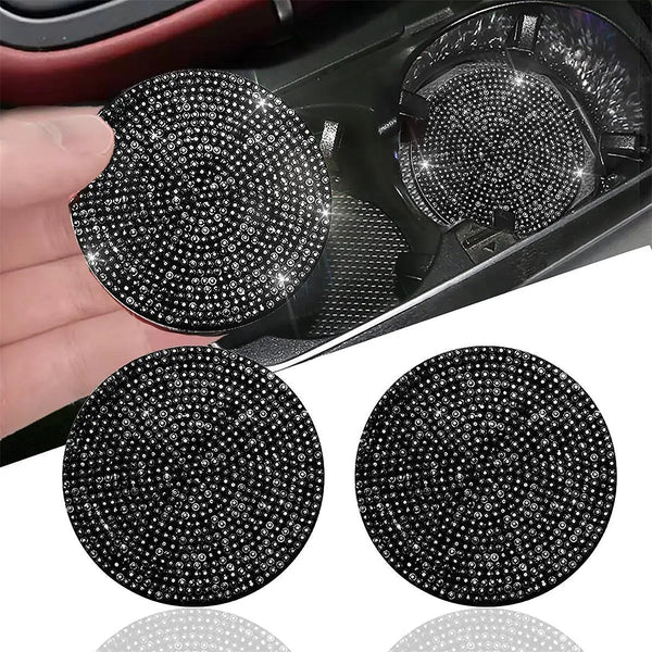 Two round black imitation diamond car cup coasters are shown, one being held by a hand.
