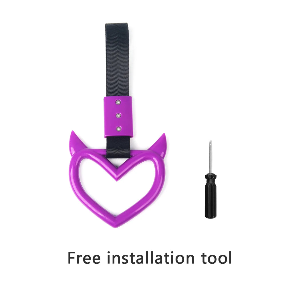 A purple heart-shaped hand pull ring and a black strap used as a free installation tool for a car rear bumper warning.