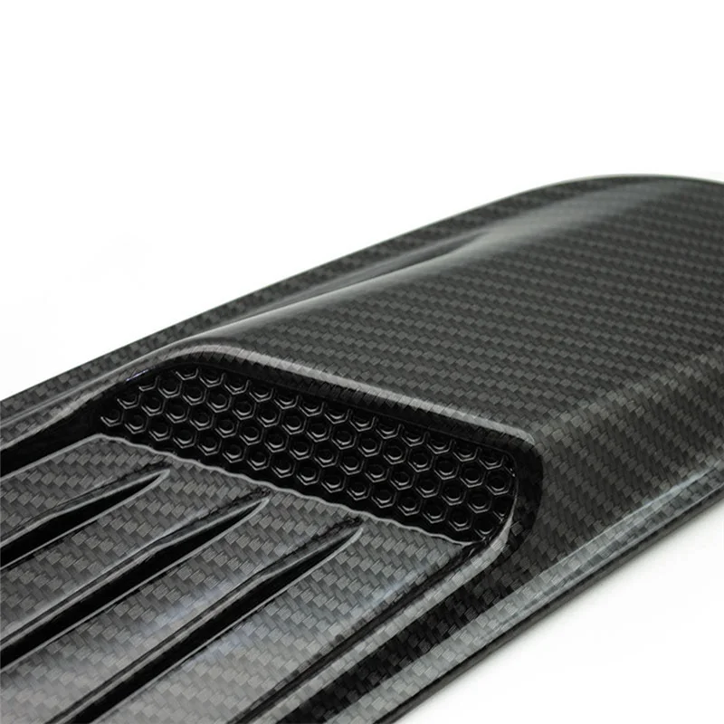 Close-up view of a black carbon fiber retrofit false air outlet hood for a Ford Mustang