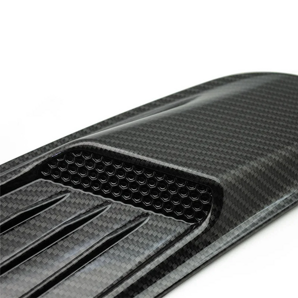 Close-up view of a black carbon fiber retrofit false air outlet hood for a Ford Mustang