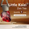 A red, skull-shaped Zen Tea bottle with a white cork is shown on a wooden surface.