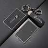 Un porte-clés en métal avec une coque NFC noire est montré sur une surface sombre.