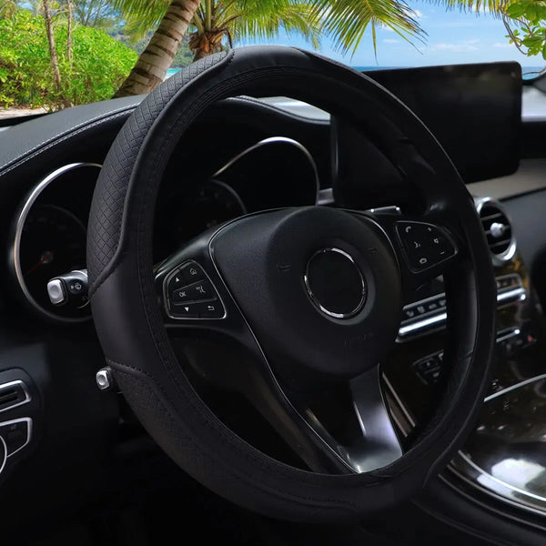 Close-up view of a black embossed leather steering wheel cover inside a car interior.