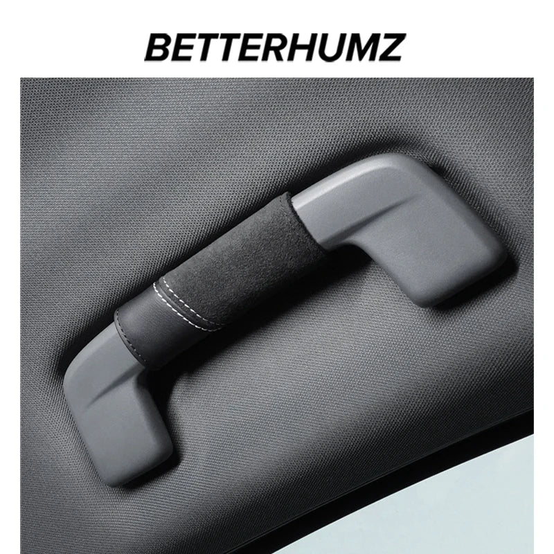 A gray Alcantara car roof handle cover with a padded grip is shown on a dark fabric surface.