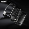 A black carbon fiber car key case cover with a removable key and electronic components.