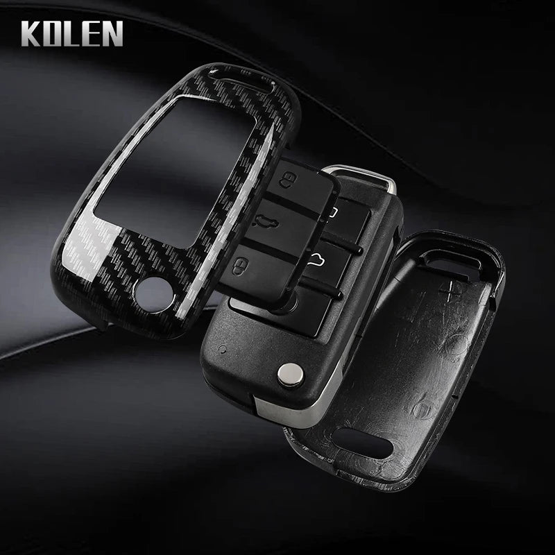 A black carbon fiber car key case cover with a removable key and electronic components.