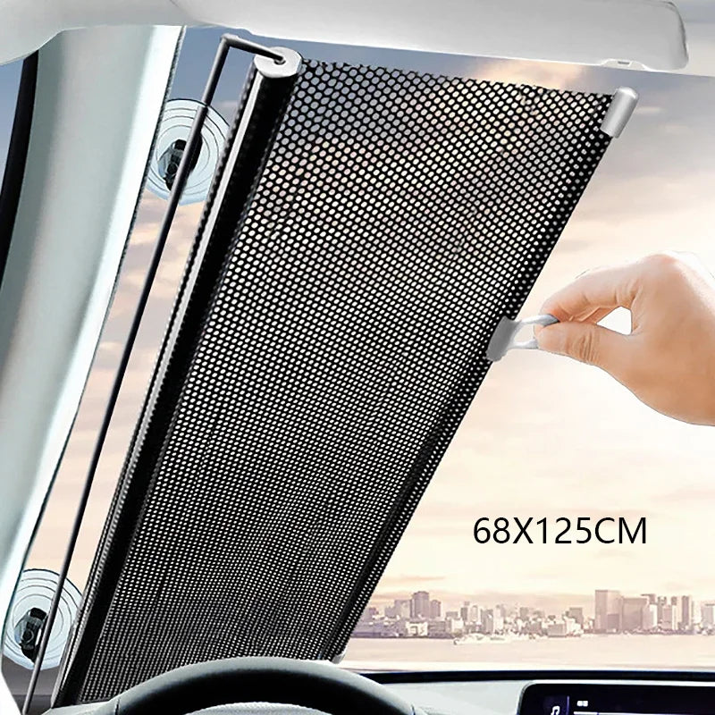A black retractable car windshield sun shade is shown being deployed in a vehicle interior.